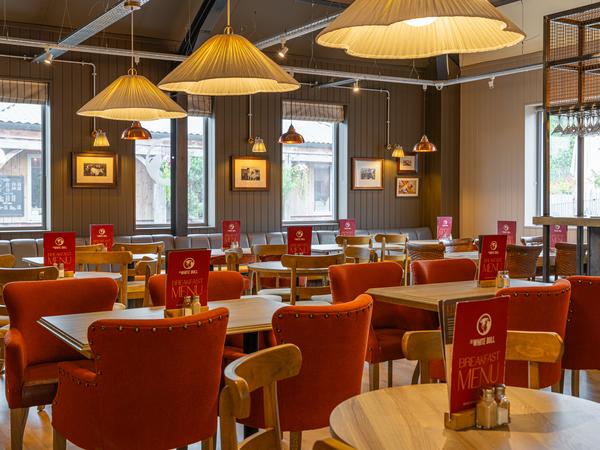 Red velvet chairs and oak tables in the White Bull dining room