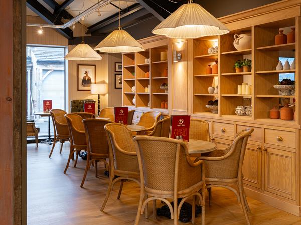 Oak shelving, framed pictures and wicker chairs