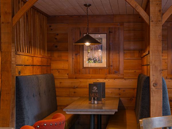 A wood-panelled snug with red chairs
