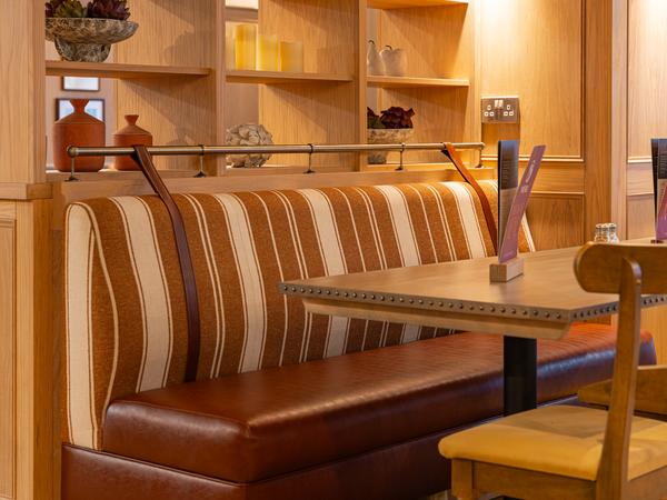 A striped booth beside oak panelling